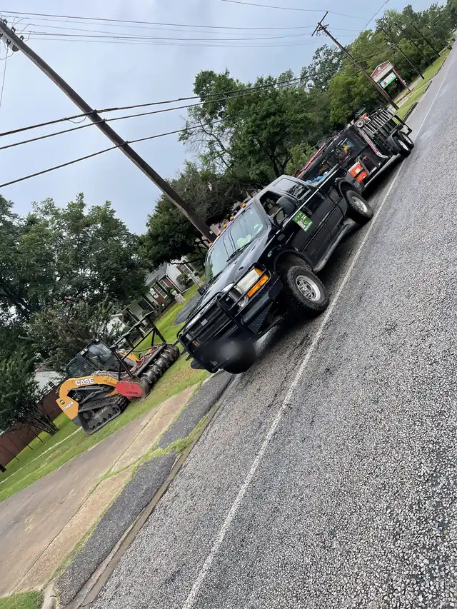 Polo's black pickup and trailer at the curb with the track loader on the verge